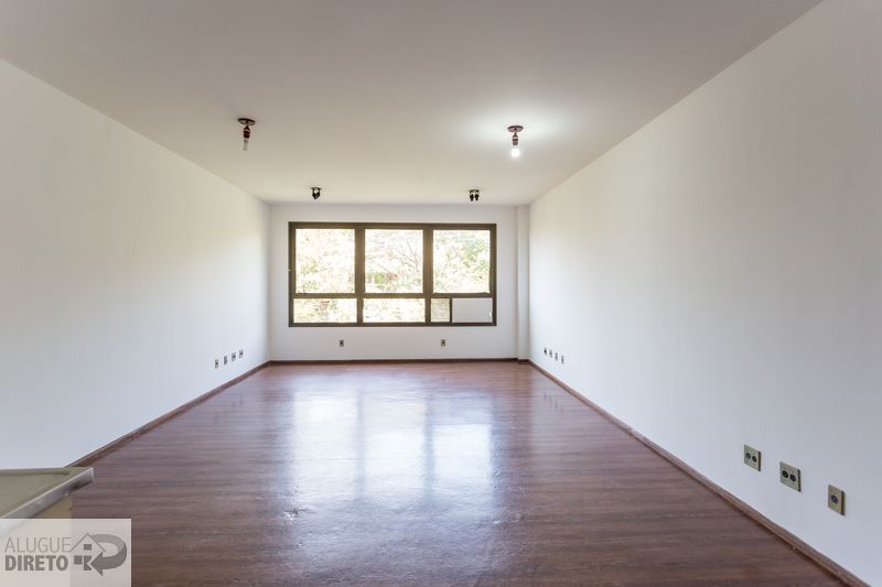 Sala comercial ampla com piso laminado e iluminação natural